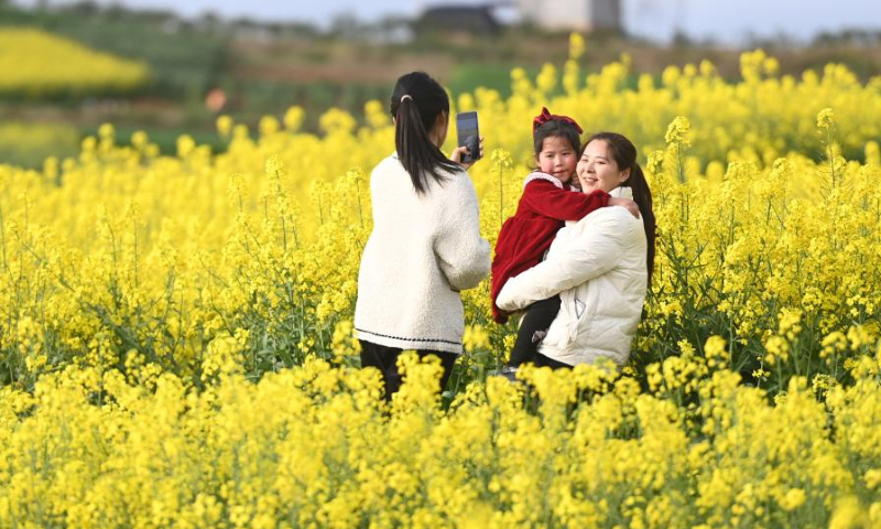 Tourists take pictures in cole flower fields in Yangxian County of Hanzhong City, northwest China's Shaanxi Province, March 17, 2023. As the temperature gradually rises, the cole flowers in full bloom have attracted many tourists to Hanzhong. In recent years, the rural revitalization of Hanzhong has been greatly promoted by the development of ecological agriculture and tourism. (Photo by Zou Jingyi/Xinhua)