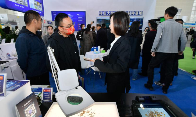 A visitor asks for information to an exhibitor during the 14th China International Seed Expo in north China's Tianjin, March 18, 2023. The 14th China International Seed Expo and the 19th National Seed Information Exchange and Commodity Trading Fair kicked off in Tianjin on Saturday, and the China Tianjin Seed Industry Revitalization Conference 2023 and Tianjin International Seed Expo 2023 were also held here, attracting participants from more than 1,200 seed enterprises, scientific research institutions and seed production bases. (Xinhua/Sun Fanyue)