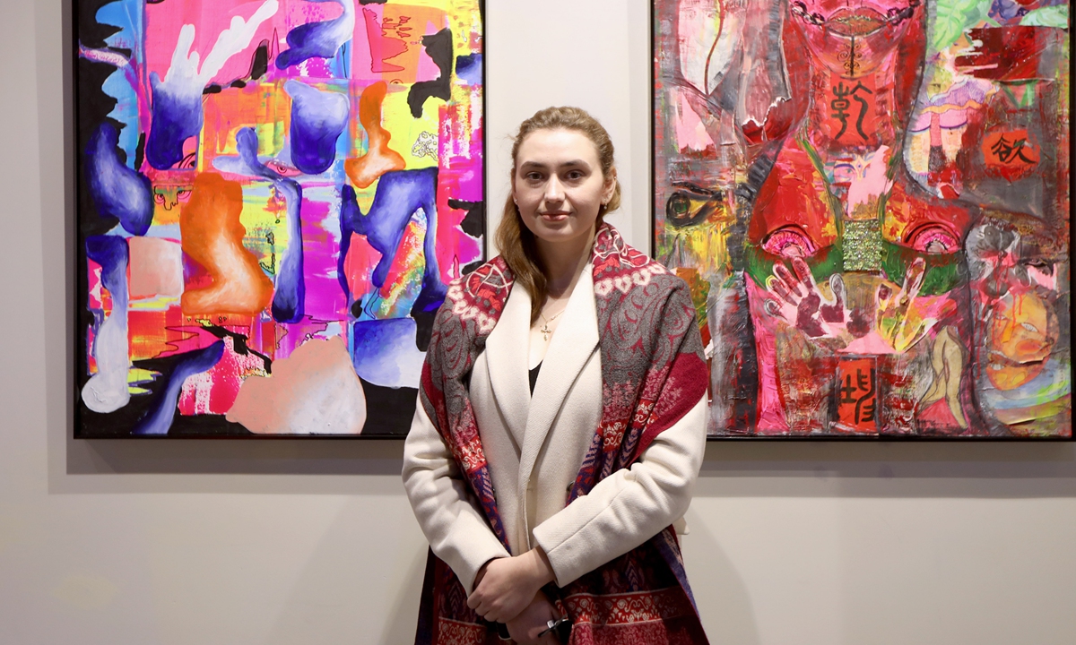 Podareva Anastasia stands in front of her paintings during her exhibition at the Changshuo Culture Center in Shanghai on January 7, 2023. 
