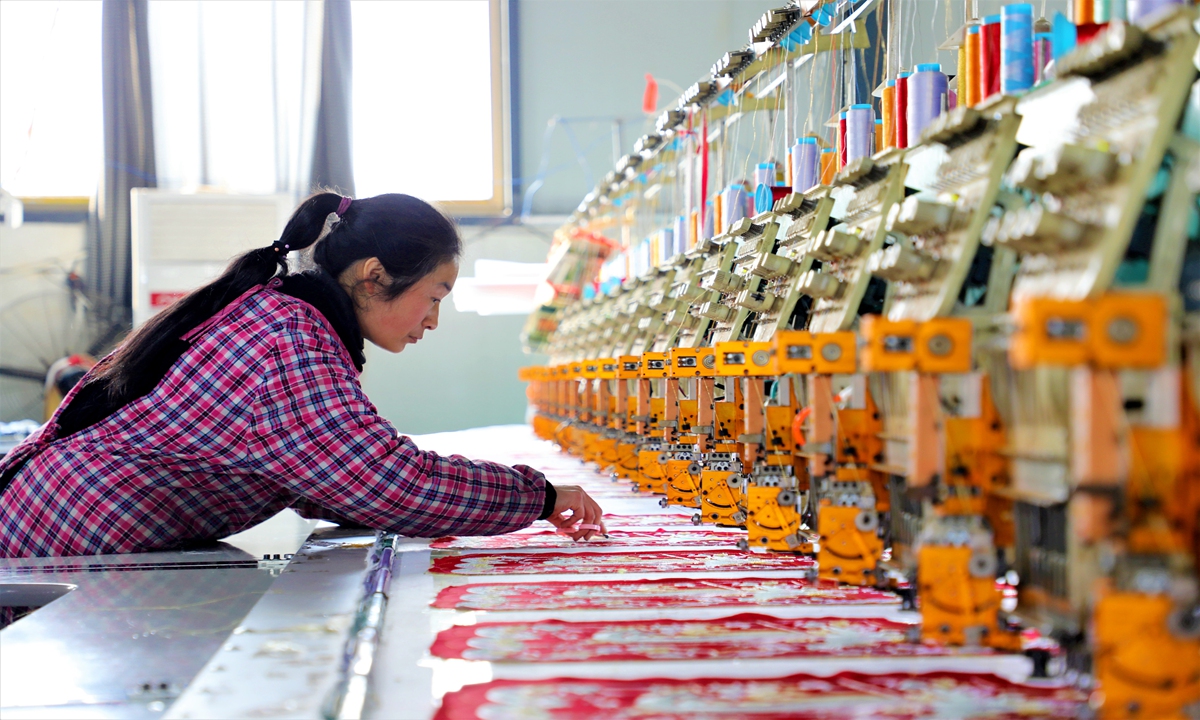 A worker processes traditional clothing on a production line in Zaozhuang, East China's Shandong Province on March 7,
2023. The local manufacturing base has received 12,000 orders so far this year, offering vacancies for more than 100 local
female employees with a monthly income from 3,000 yuan ($432.71) to 8,000 yuan. Photo: cnsphoto