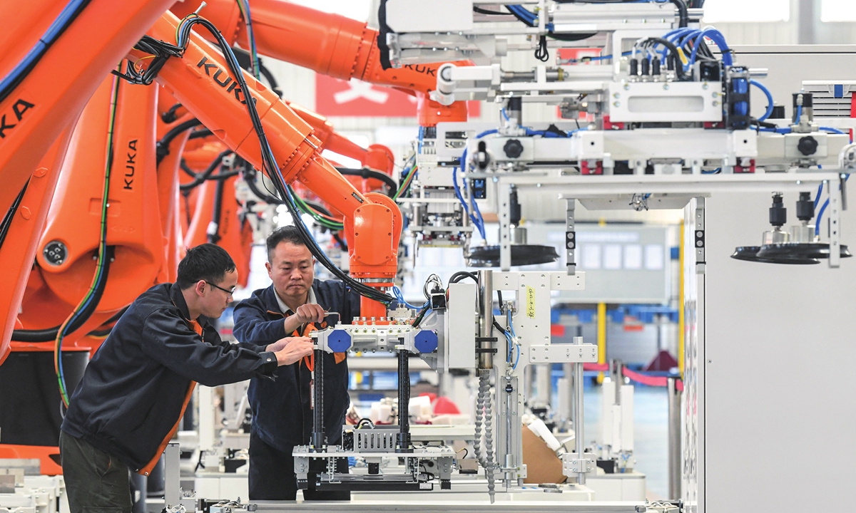 Workers debug intelligent robotic arms at a factory in Ningde, East China’s Fujian Province on March 8, 2023. China is moving to promote the high-quality development of its manufacturing sector, amid efforts to advance new industrialization. Photo: cnsphoto