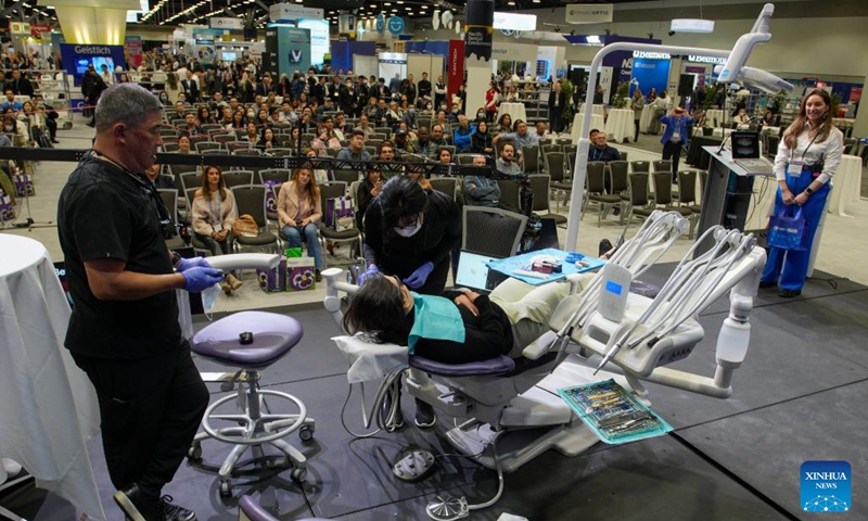 Participants watch a live demonstration of a surgical procedure at the 2023 Pacific Dental Conference in Vancouver, British Columbia, Canada, on March 9, 2023. The three-day event featured a trade show with more than 225 exhibitors showcasing their latest products, technologies and services in the dental industry.(Photo: Xinhua)
