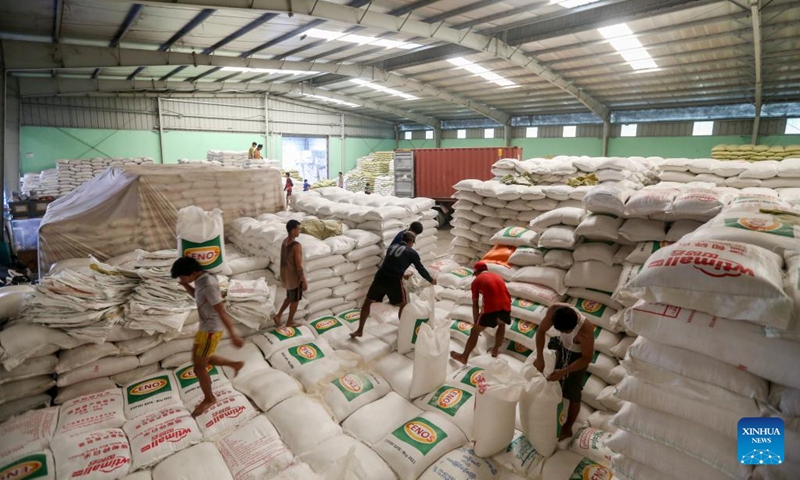 Workers carry packages of rice at a warehouse in Yangon, Myanmar, March 8, 2023. Myanmar exported 106,855 tons of rice in February this year, as compared to 171,811 tons of rice exported in January, the Myanmar Rice Federation (MRF) said on Tuesday.(Photo: Xinhua)