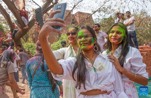 Women smeared with colored powder take selfies during a celebration of the Holi festival in New Delhi, India, March 8, 2023. (Xinhua/Javed Dar)