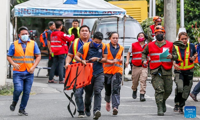Rescuers run towards a mock victim during a national simultaneous earthquake drill at the Camp Aguinaldo in Quezon City, the Philippines, March 9, 2023.(Photo: Xinhua)