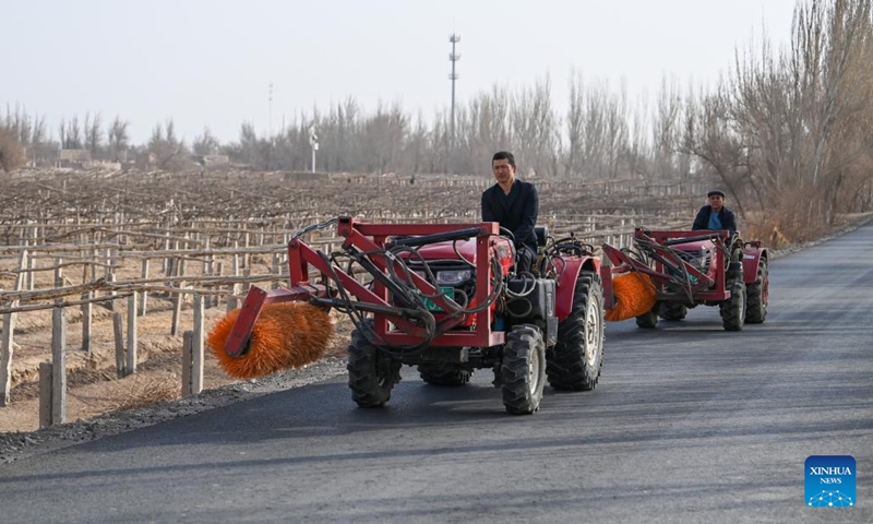 Farmers drive machines to the grape field in Putao Town of Turpan, northwest China's Xinjiang Uygur Autonomous Region, March 8, 2023. Every winter, farmers here bury grape vines underground to keep them warm during the cold weather and dig them out and put them on trellises in the springtime. More farming machines have been put into use, which not only saves labor costs, but also greatly increases efficiency.(Photo: Xinhua)