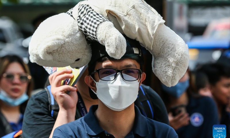 A man uses a stuffed toy to protect his head during a national simultaneous earthquake drill at the Camp Aguinaldo in Quezon City, the Philippines, March 9, 2023.(Photo: Xinhua)