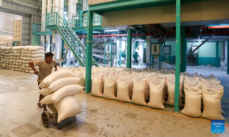 A worker transfers packages of rice at a warehouse in Yangon, Myanmar, March 8, 2023. Myanmar exported 106,855 tons of rice in February this year, as compared to 171,811 tons of rice exported in January, the Myanmar Rice Federation (MRF) said on Tuesday.(Photo: Xinhua)