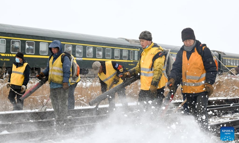 Staff members clear ice and snow along a railway track at Tongbei Railway Station in Beian, northeast China's Heilongjiang Province, March 15, 2023. China Railway Harbin Bureau Group Co., Ltd. on Wednesday launched an emergency plan to ensure railway transportation safety as heavy snow hit parts of the province.(Photo: Xinhua)