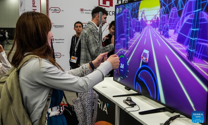 A girl tries on touchless driving technology at South by Southwest Conference and Festivals in Austin, Texas, the United States, on March 12, 2023. In a style like a colorful kaleidoscope with patterns changing at every twist, South by Southwest (SXSW), a conglomerate of film, interactive media, music festivals and conferences, is held in Austin from March 10 to March 19.(Photo: Xinhua)