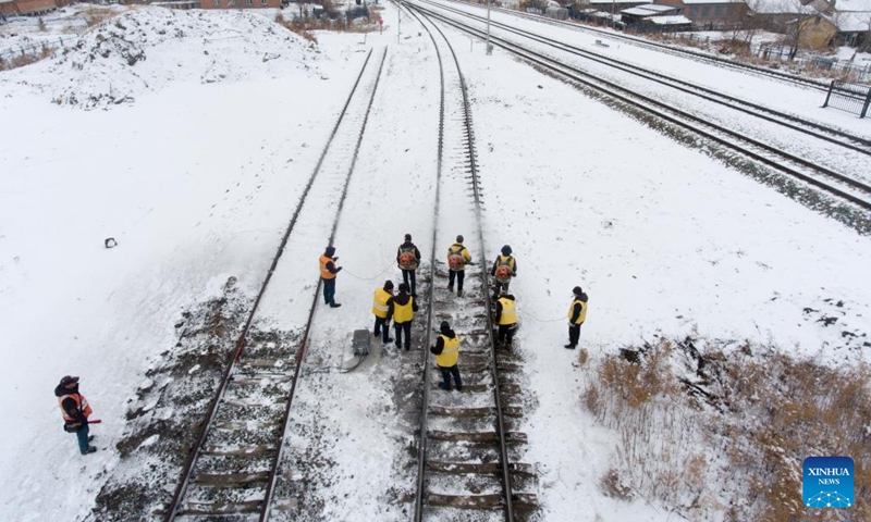 This aerial photo shows staff members clearing ice and snow along a railway track at Tongbei Railway Station in Beian, northeast China's Heilongjiang Province, March 15, 2023. China Railway Harbin Bureau Group Co., Ltd. on Wednesday launched an emergency plan to ensure railway transportation safety as heavy snow hit parts of the province.(Photo: Xinhua)