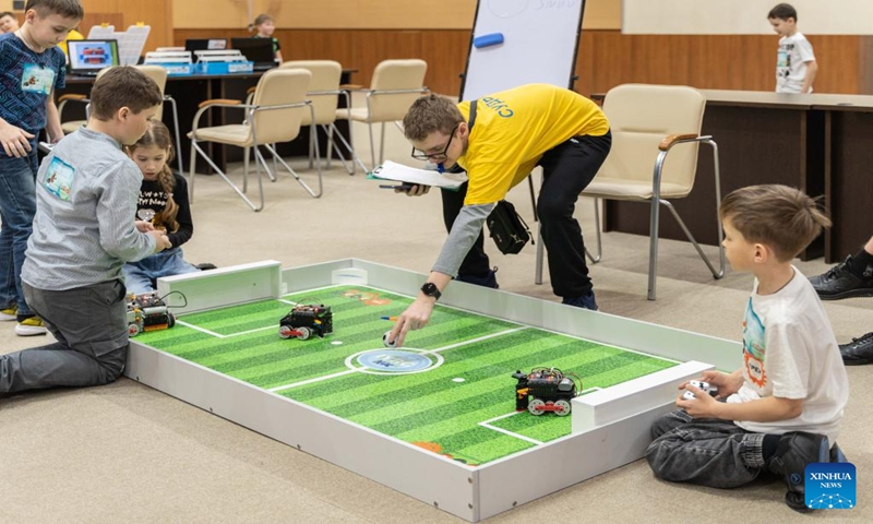 Young people use remote control to operate their robots to compete in a soccer game in Vladivostok, Russia, March 11, 2023. The Russian far east youth robot soccer competition is held at the Far Eastern Federal University here Saturday. Students from cities as Vladivostok, Nakhodka and Khabarovsk come to compete with robots they assembled by themselves. (Photo: Xinhua)