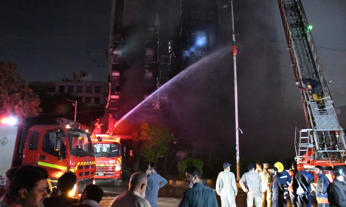 Pakistani firefighters struggle to control a fire that broke out in a 16-story building at Shahrah-e-Faisal in Karachi, Pakistan on March 12, 2023, resulting in injuries to one person. Photo: VCG
