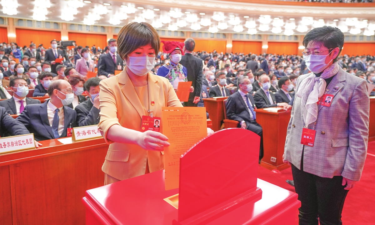 A deputy to the 14th National People's Congress (NPC) votes at the fifth plenary meeting of NPC's first session on March 12, 2023. During the session, the national legislature decided on the new lineup of the State Council. Photo: VCG