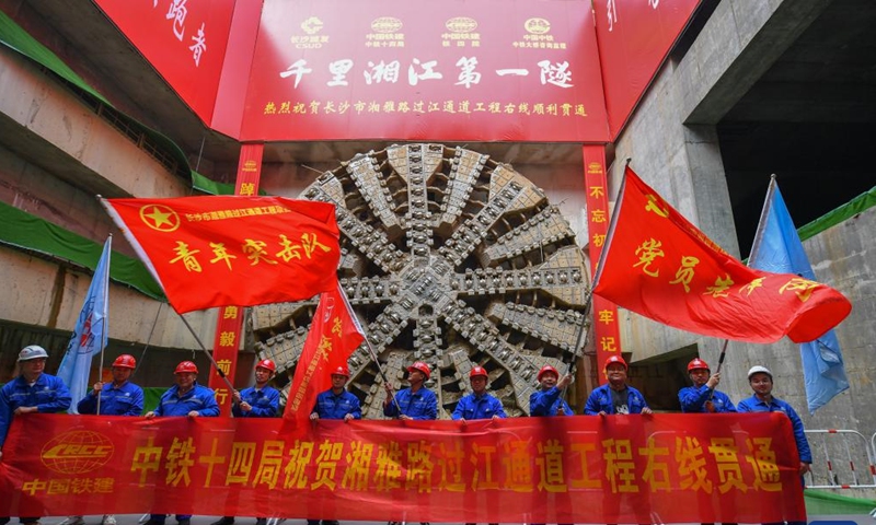 Workers of China Railway 14th Bureau Group Corporation Limited celebrate the drill-through of the right-line tunnel of the Xiangya Road river-crossing passway in Changsha, central China's Hunan Province on March 12, 2023. The drill-through of the right-line tunnel, together with the left-line tunnel drilled through a year ago, means the construction of the main part of the two-way river-crossing passway is near completion. (Xinhua/Chen Zeguo)