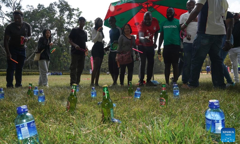 People participate in a ring toss game during the first Kenya Tsingtao Beer Festival in Nairobi, Kenya, March 11, 2023. The first Kenya Tsingtao Beer Festival was held here on Saturday. (Xinhua/Han Xu)