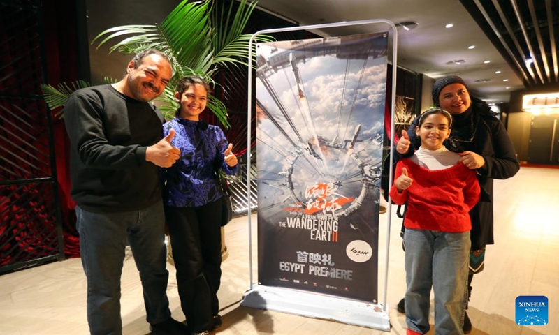 People pose for a photo with a poster of the movie The Wandering Earth II at a theater in Giza, Egypt, March 11, 2023. The premiere of China's latest sci-fi blockbuster, The Wandering Earth II, attracted hundreds of Egyptian filmmakers, sci-fi fans and movie lovers in Egypt's Giza Province on Saturday. According to the schedule, The Wandering Earth 2 will be officially released to the public in Egyptian theaters on March 15. (Photo:Xinhua)