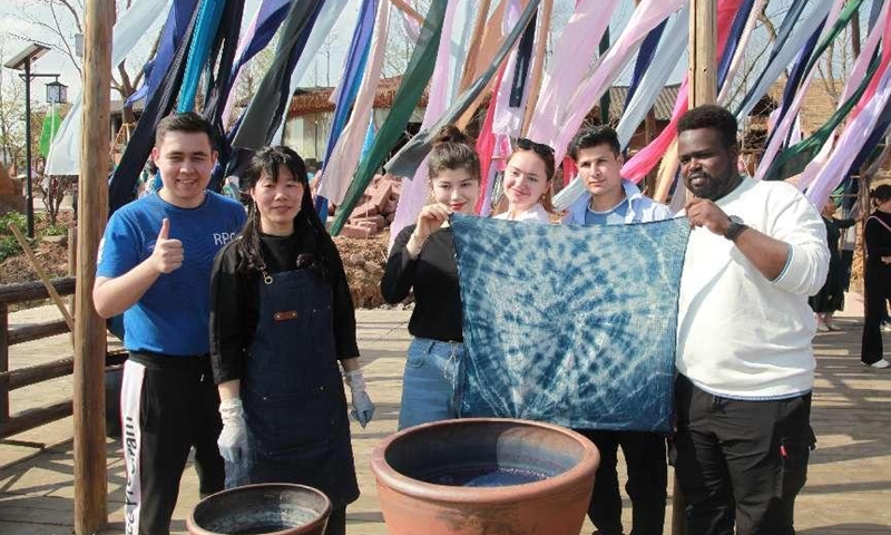 Tourists experience tie dyeing, a state-level intangible cultural heritage