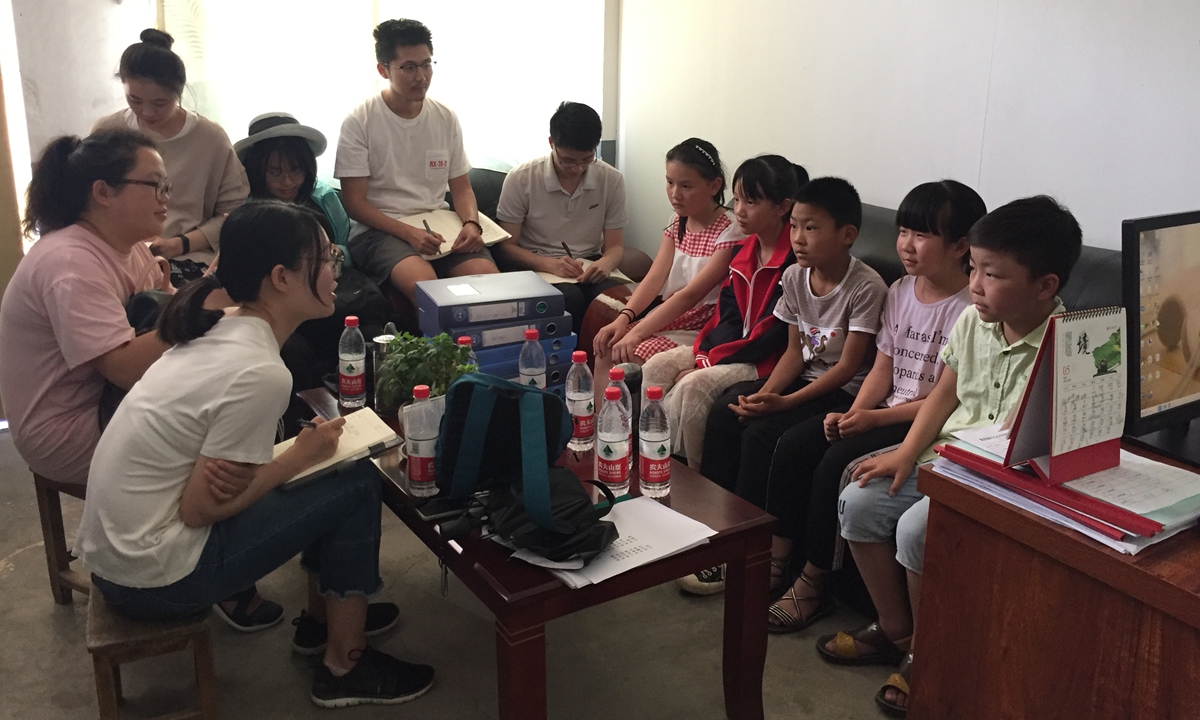Researchers from China Rural Governance Research Center, Wuhan University (WHU) talk to a group of left-behind children. Photo: Courtesy of Yi Zhuo