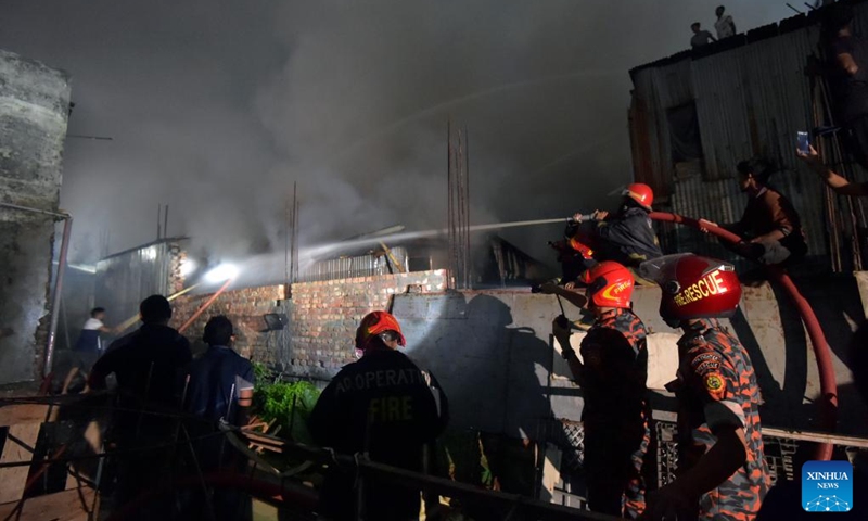 Firefighters spray water to extinguish a fire at a slum in Dhaka, Bangladesh on March 13, 2023. A massive fire tore through one of the largest slums in the Bangladeshi capital Dhaka, destroying at least 100 shanties. (Photo:Xinhua)