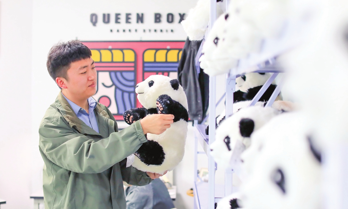 Liu Tao, a Chinese entrepreneur from Chengdu, Southwest China's Sichuan Province, checks one of his giant panda dolls on March 14, 2023. His giant panda dolls have been sold in more than 50 countries and regions. 
Photo: IC