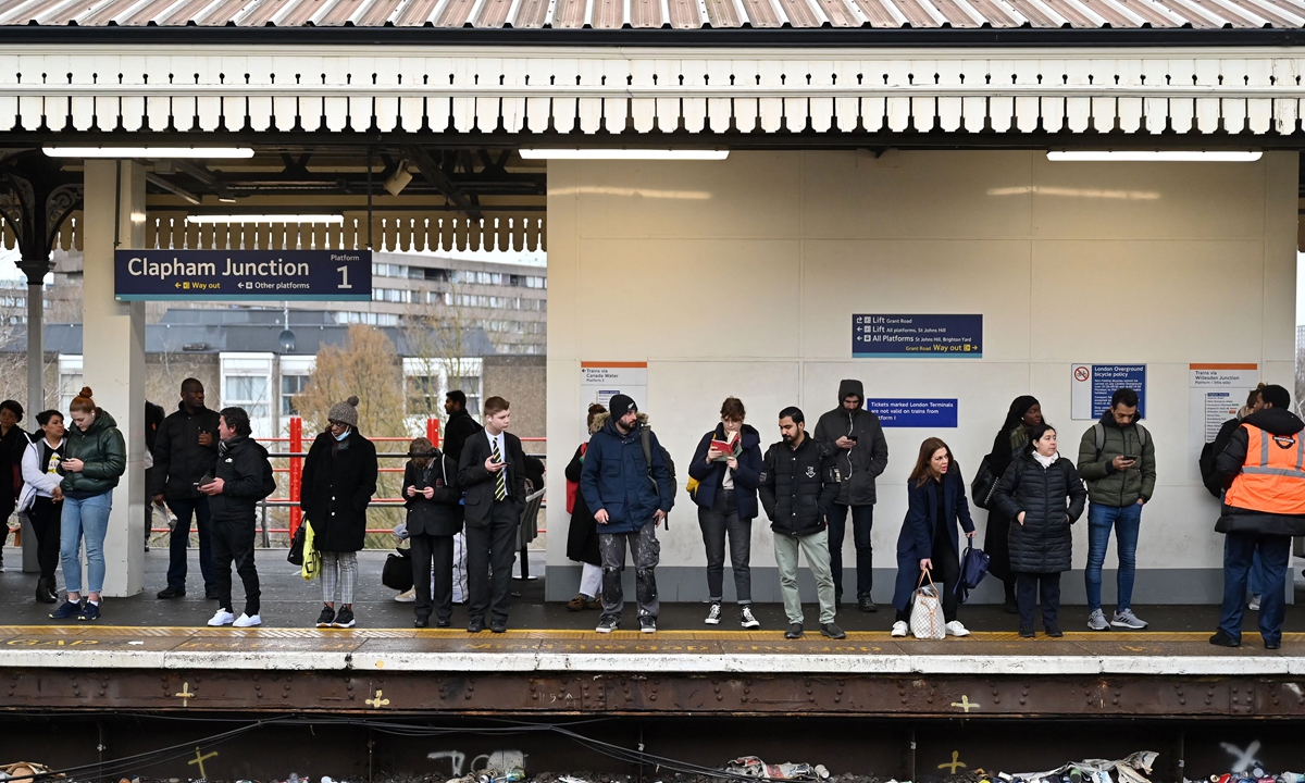 Commuters wait for a train at Clapham Junction station in south London on March 16, 2023 as train drivers staged a strike over pay. Train operators said they would 