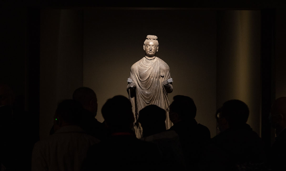 Main: Spectators view a standing Buddha statue from the 1st-2nd century AD at the exhibition. The distinct Europid facial outline shows the influence of Greek civilization on Gandharan Buddhist art. Photo: Li Hao/GT