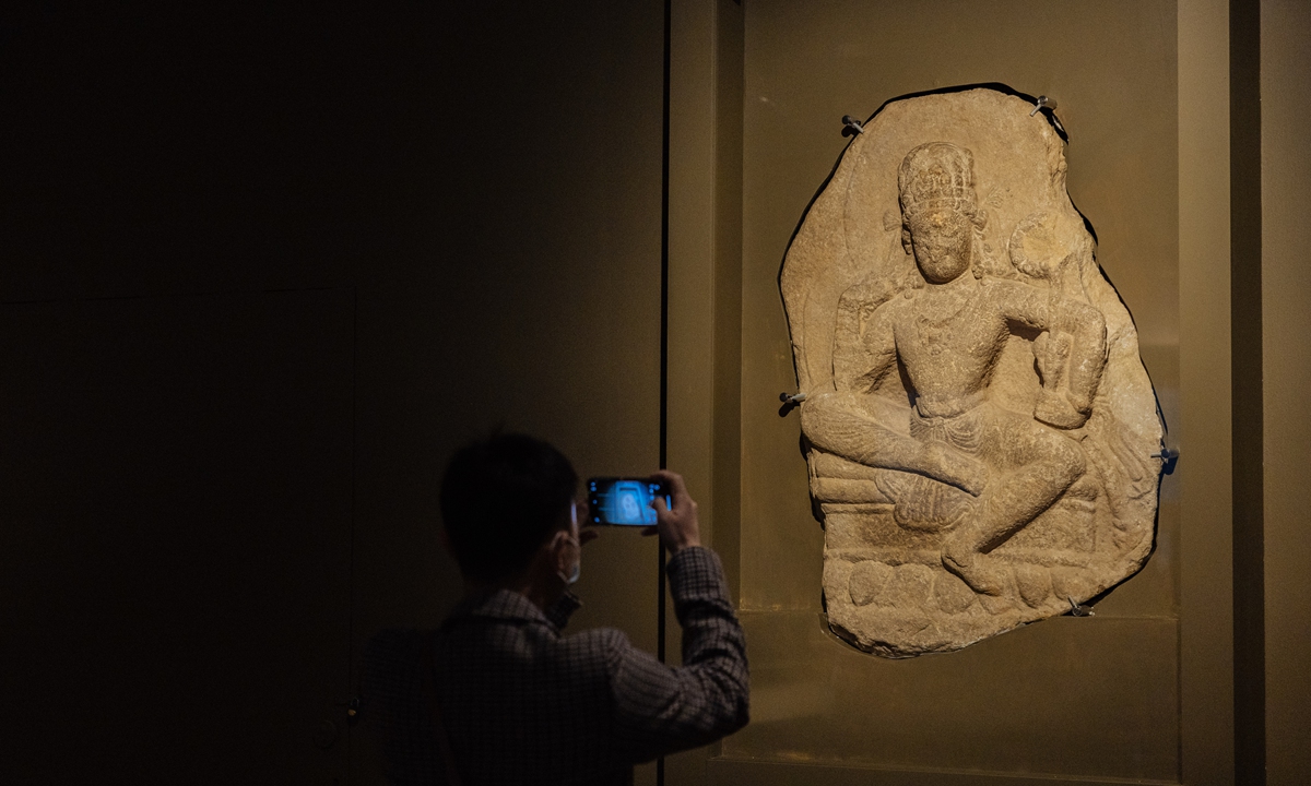 A visitor takes a photo of a late Swat-style statue of Avalokitesvara at the exhibition. The statue likely dating back to 7th-8th century was discovered in the Swat District of northeastern Pakistan. Photo: Li Hao/GT