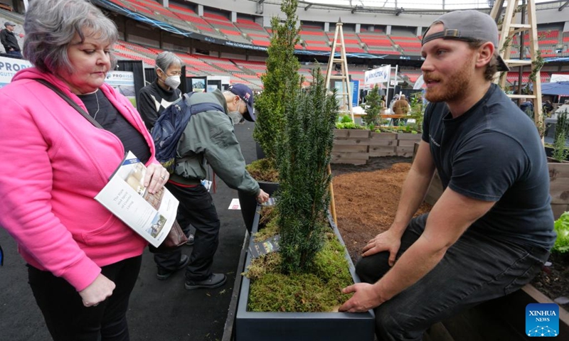 People communicate at the BC Home and Garden Show in Vancouver, British Columbia, Canada, on March 16, 2023. The annual event featured over 300 exhibitors and expert presentations and will run from March 16 to March 19 at the BC Place stadium.(Photo: Xinhua)