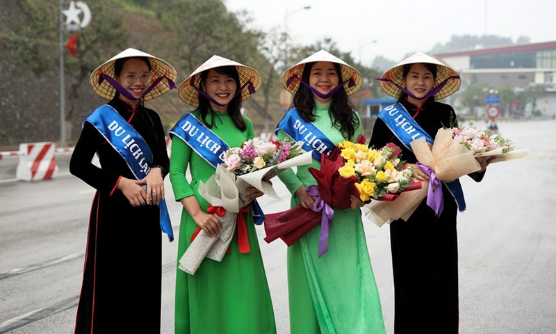 Vietnamese staff welcomed Chinese tourists with flowers in their hands at the Huu Nghi International Border Gate in northern Vietnam's Lang Son province, on March 15, 2023.(Photo: Xinhua)