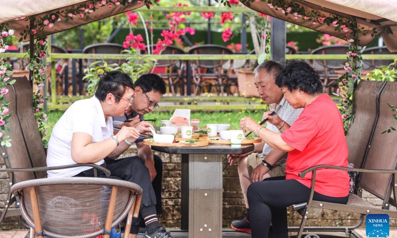 Tourists enjoy food at a scenic spot featuring tropical fruits in Qionghai, south China's Hainan Province, March 15, 2023. As a key project of a pilot zone for international agricultural cooperation in Hainan Province, the scenic spot has introduced more than 500 kinds of tropical fruits from all over the world, which promotes the integrated development of agriculture and tourism.(Photo: Xinhua)
