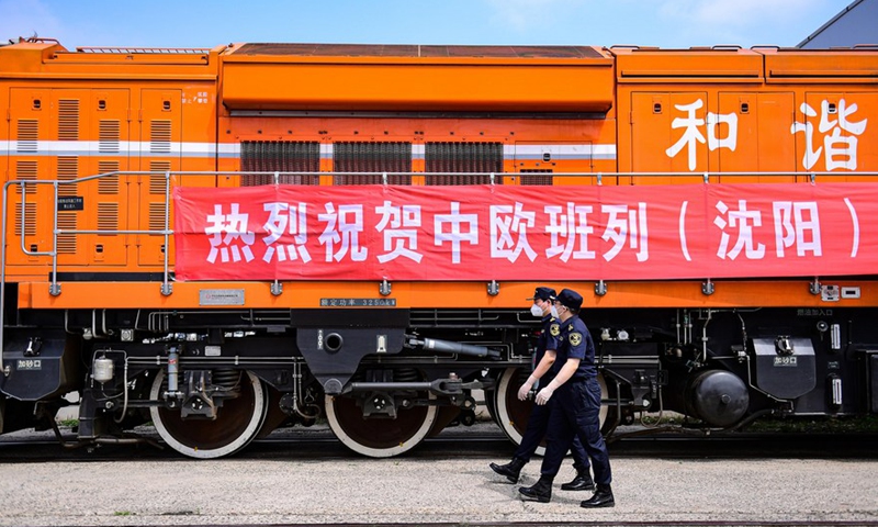 Customs officers pass a China-Europe freight train at the Shenyang East Railway Station in Shenyang, northeast China's Liaoning Province, June 16, 2022. (Xinhua/Yang Qing)