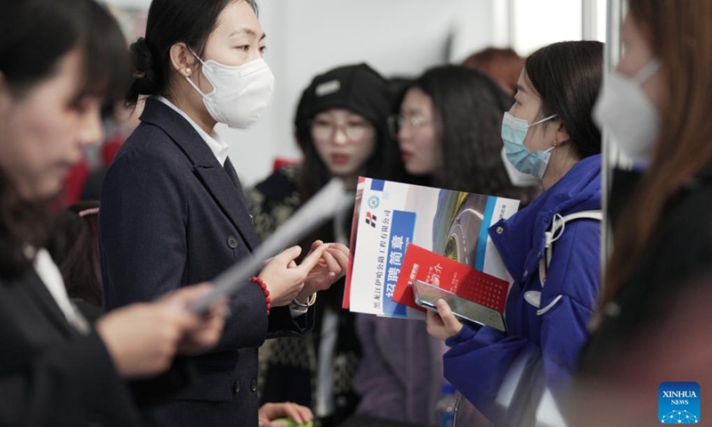 A job seeker (2nd R) inquires about vacant position information at a job fair in Harbin, northeast China's Heilongjiang Province, March 18, 2023. More than 500 on-line and off-line recruiting events have been scheduled during this job fair, the largest of its kind in recent years held in the province, offering over 115,000 vacant positions in total. (Photo:Xinhua)
