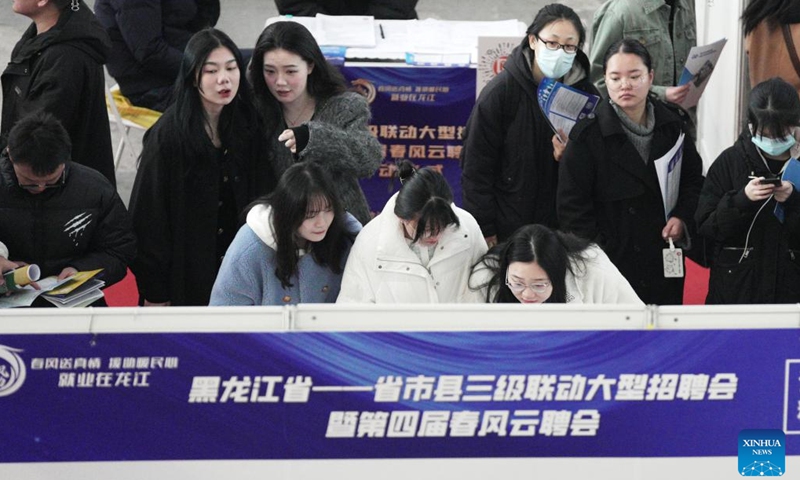 Job seekers search for vacancy on a bulletin at a job fair in Harbin, northeast China's Heilongjiang Province, March 18, 2023. More than 500 on-line and off-line recruiting events have been scheduled during this job fair, the largest of its kind in recent years held in the province, offering over 115,000 vacant positions in total. (Photo:Xinhua)