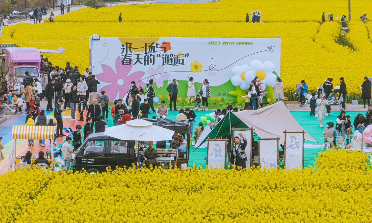 Tourists enjoy spring in the fields during a rape flower festival in a village in Taizhou, East China's Zhejiang Province, on March 19, 2023. With the development of local tourism resources, more rural areas are holding festivals to attract tourists and help the villagers make money. Photo: VCG