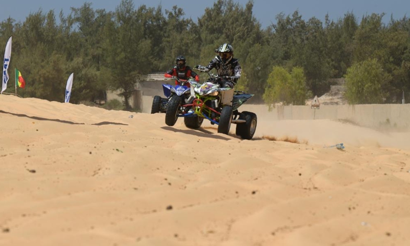 Racers compete during a beach motocross race near Lake Retba in Senegal on March 19, 2023. (Xinhua/Han Xu)