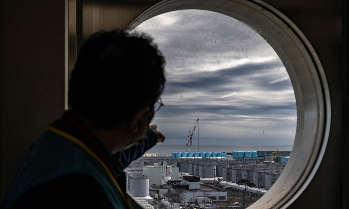 Inset: A risk communicator gestures toward storage tanks holding contaminated wastewater at the TEPCO Fukushima Daiichi nuclear power plant on January 20, 2023. Photos: VCG