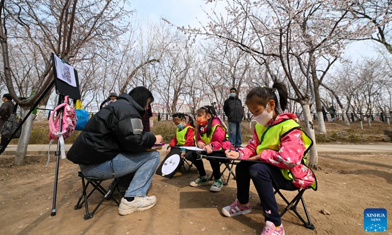 Children learn to draw peach blossoms on the peach blossom embankment along the Grand Canal in Hongqiao district, north China's Tianjin, on March 19, 2023. As the weather gets warmer, the peach blossoms here are in full bloom and have attracted many tourists. (Xinhua/Sun Fanyue)