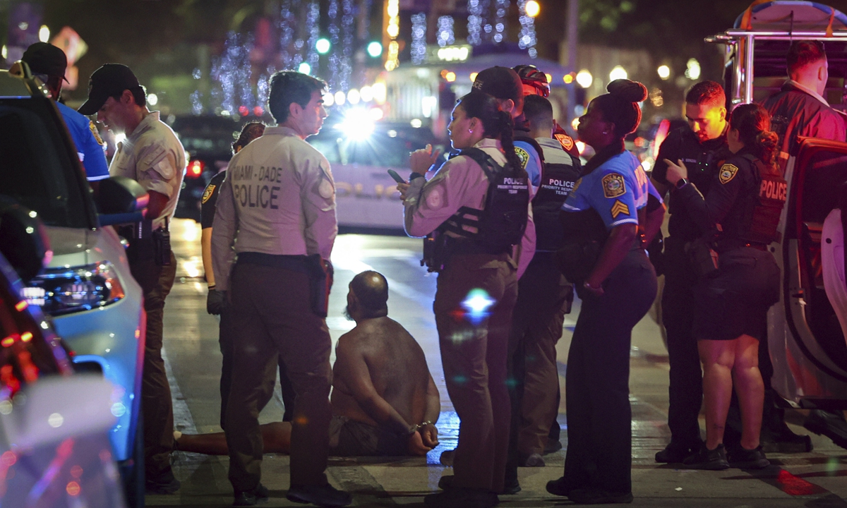 A man sits on the ground handcuffed after witnesses say he appeared to be brandishing a knife on March 19, 2023 local time in Miami, Florida. Florida announced a state of emergency and curfew on March 19, 2023 after two deadly shootings. Photo: VCG