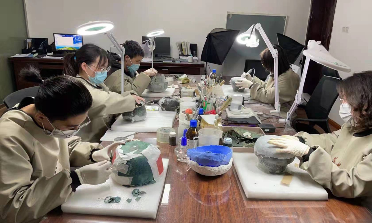 Experts from the Chinese Academy of Cultural Heritage restore corroded metal relics at Liye Qin Slips Museum. Photo: Courtesy of Ma Jingyu