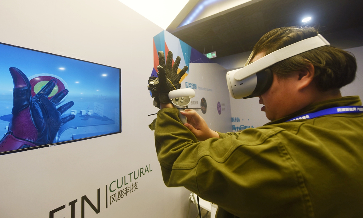 A visitor experiences a haptic glove with human-computer interaction at a summit in Hangzhou, East China's Zhejiang Province on March 21, 2023. Many digital technology companies bring their new products to the summit, which is aimed at helping the high quality development of virtual reality and metaverse industry. Photo: VCG