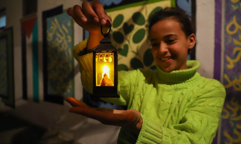 A Palestinian girl holds a lantern to celebrate the upcoming Ramadan, in Gaza City, on March 20, 2023.(Photo: Xinhua)