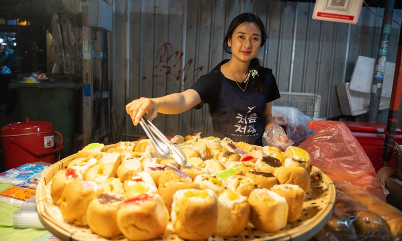 A vendor prepares food at a night market in Vientiane, Laos on March 14, 2023.(Photo: Xinhua)