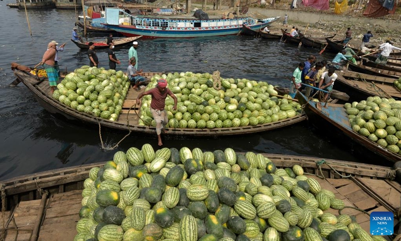 Boats loaded with watermelons are berthed in a river near a wholesale market in Dhaka, Bangladesh, March 21, 2023. Photo: Xinhua