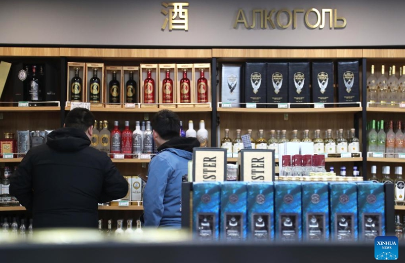 People shop for liquor at a Russian goods store in Manzhouli, north China's Inner Mongolia Autonomous Region, March 16, 2023. Popularity of Russian goods and foods has revived among local customers after the land port of Manzhouli resumes services. (Xinhua/Wang Kaiyan)