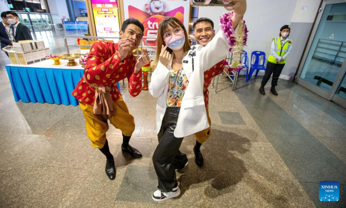 A Chinese tourist takes a selfie with Thai staff members at Don Mueang International Airport in Bangkok, Thailand, Feb 6, 2023. Photo:Xinhua