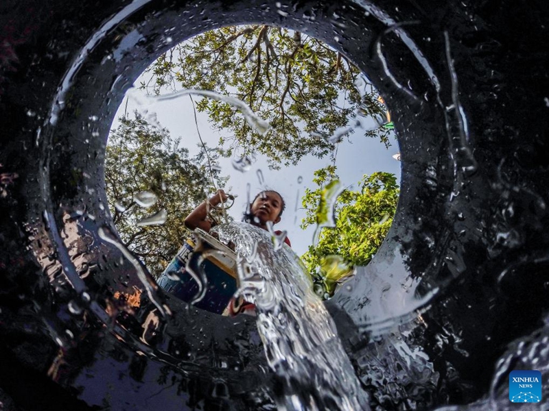A resident pours water into a bucket at a residential area on the occasion of World Water Day in Quezon City, the Philippines, March 22, 2023. (Xinhua/Rouelle Umali)