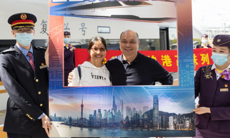 Passengers pose for photos before boarding the train G99 at Shanghai Hongqiao Railway Station in east China's Shanghai, April 1, 2023. As train G99 left Shanghai Hongqiao Railway Station for Hong Kong West Kowloon Station, the services of Shanghai-Hong Kong high-speed railway resumed on Saturday. (Xinhua/Wang Xiang)