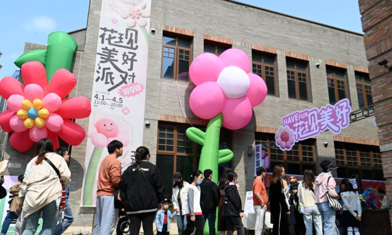 Tourists take part in an activity themed on Chinese flowering crabapple at the Wudadao historical urban area, or the Five Great Avenues, in north China's Tianjin, April 1, 2023. The Wudadao historical urban area, or the Five Great Avenues, in north China's Tianjin attracted flocks of visitors during the blooming season of Chinese flowering crabapple recently. In order to further embrace the tourism boom brought by the blossoms, Heping District of Tianjin launched a series of events themed on Chinese flowering crabapple from March 31 to April 9, featuring float parade, light show and cultural fair. (Xinhua/Zhao Zishuo)