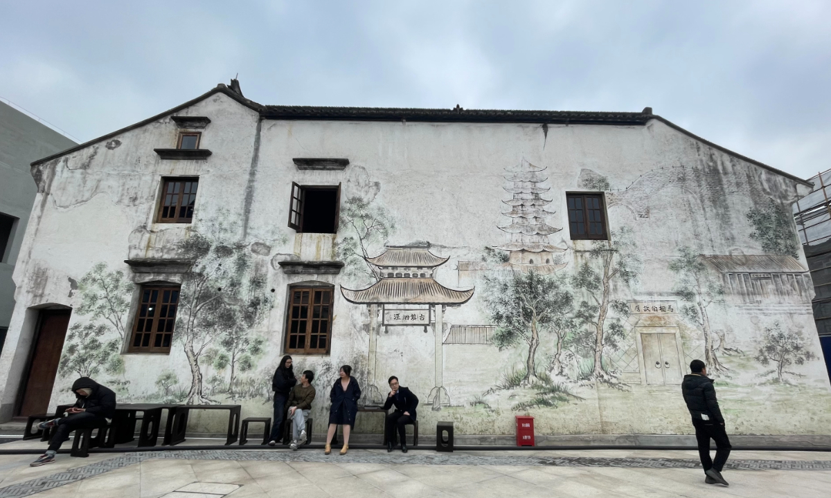Visitors take a rest in front of a wall with illustration of the classical landscapes of Sijing Ancient Town in Sijing, Shanghai, on March 18, 2023. Photo: Feng Yu/GT